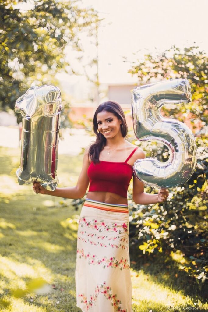 Imagen ilustra una chica Quinceañera con globos para celebrar los 15 años.